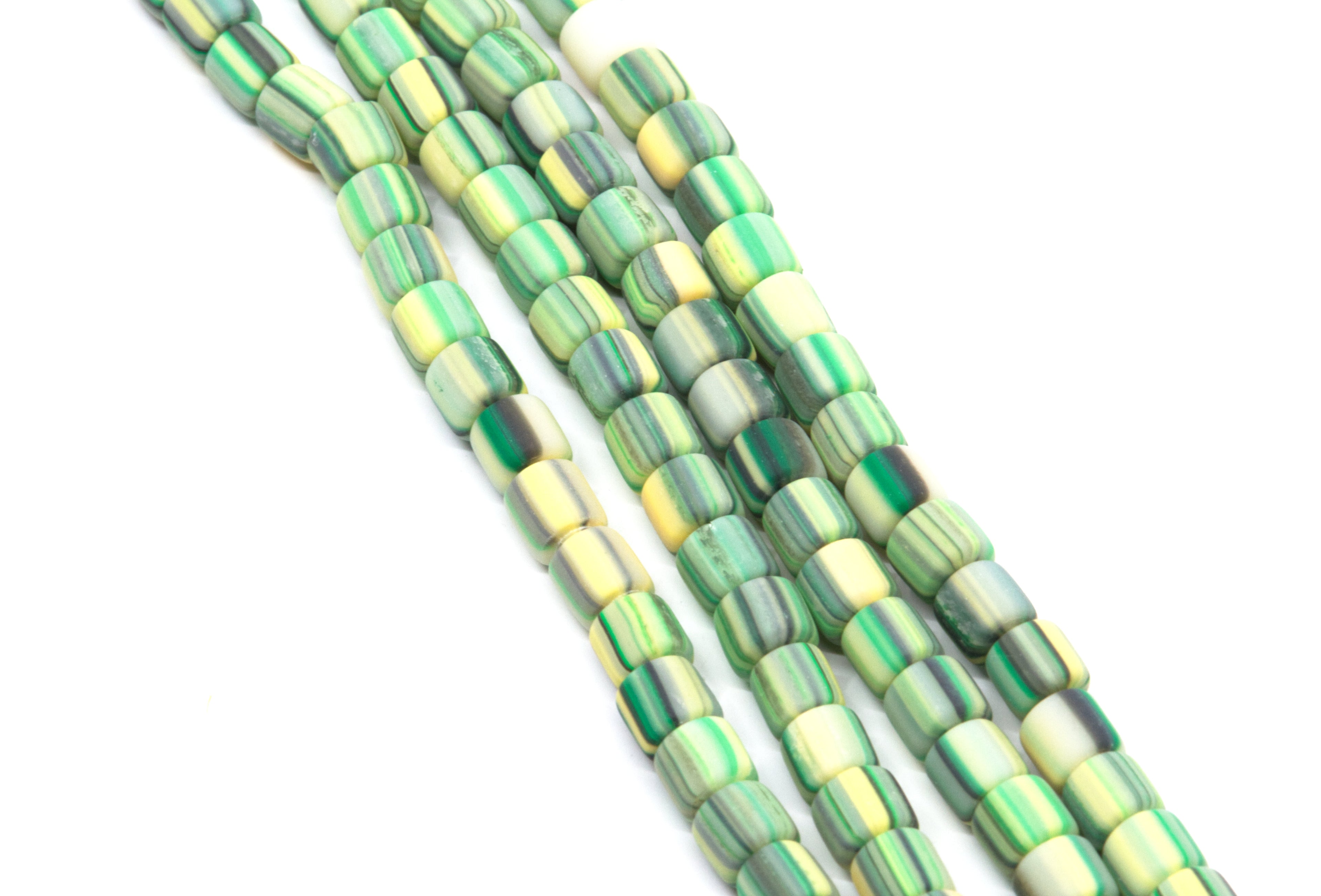 Green and yellow striped polymer clay barrel beads strands on a white background. 