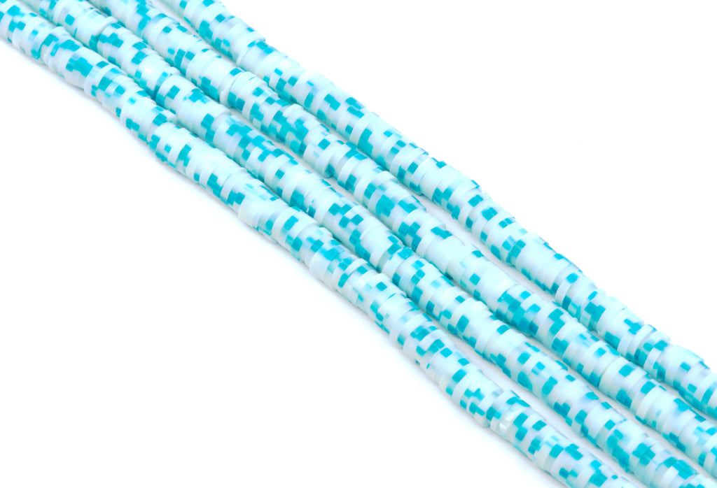 Several strands of blue polymer clay disc beads arranged diagonally on a plain white background.