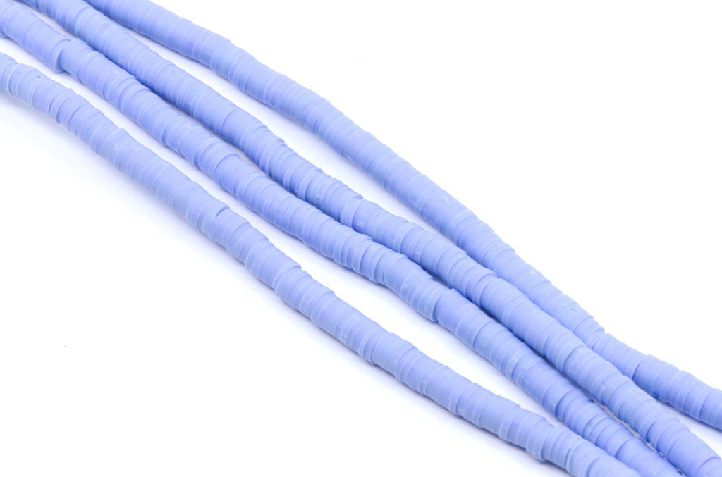 multiple strands of light blue polymer clay disc beads arranged diagonally on a clean white background.