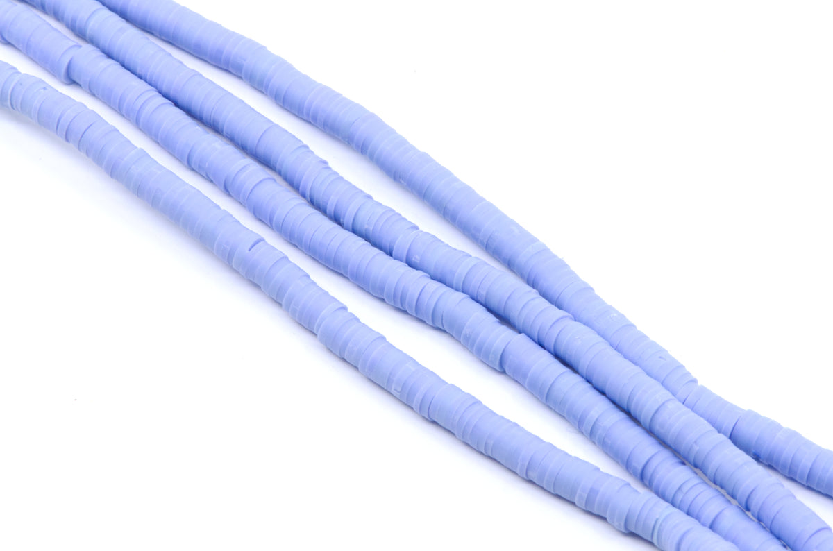 multiple strands of light blue polymer clay disc beads arranged diagonally on a clean white background.