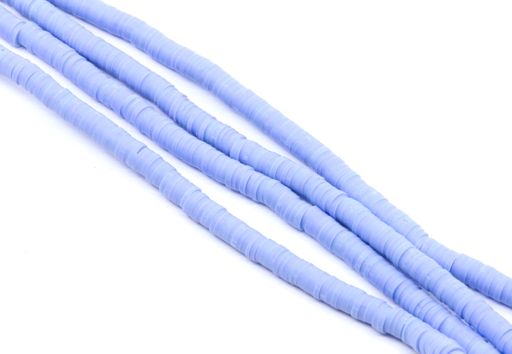 multiple strands of light blue polymer clay disc beads arranged diagonally on a clean white background.