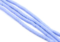 multiple strands of light blue polymer clay disc beads arranged diagonally on a clean white background.