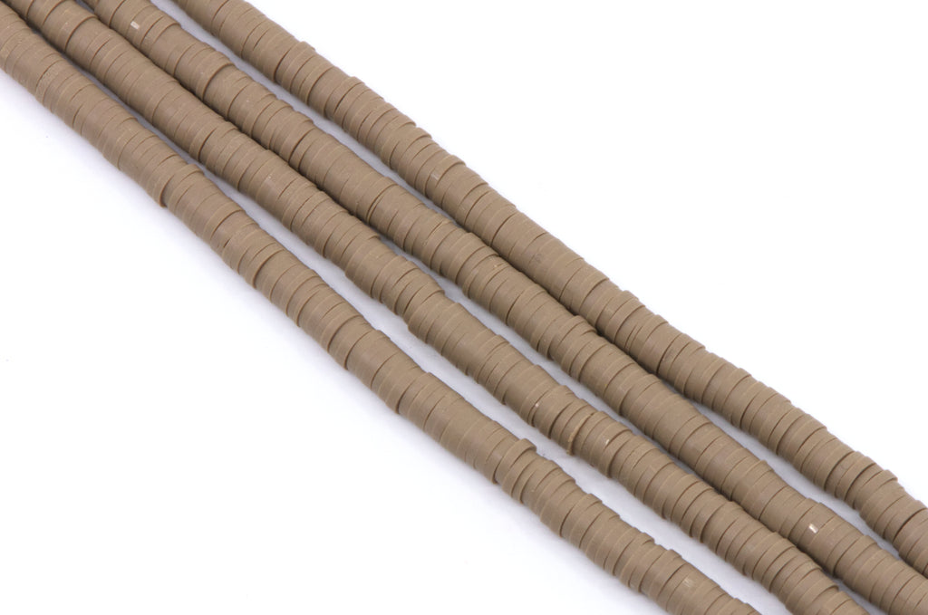 several strands of brown polymer clay disc beads arranged diagonally on a plain white background.