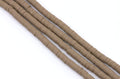 several strands of brown polymer clay disc beads arranged diagonally on a plain white background.