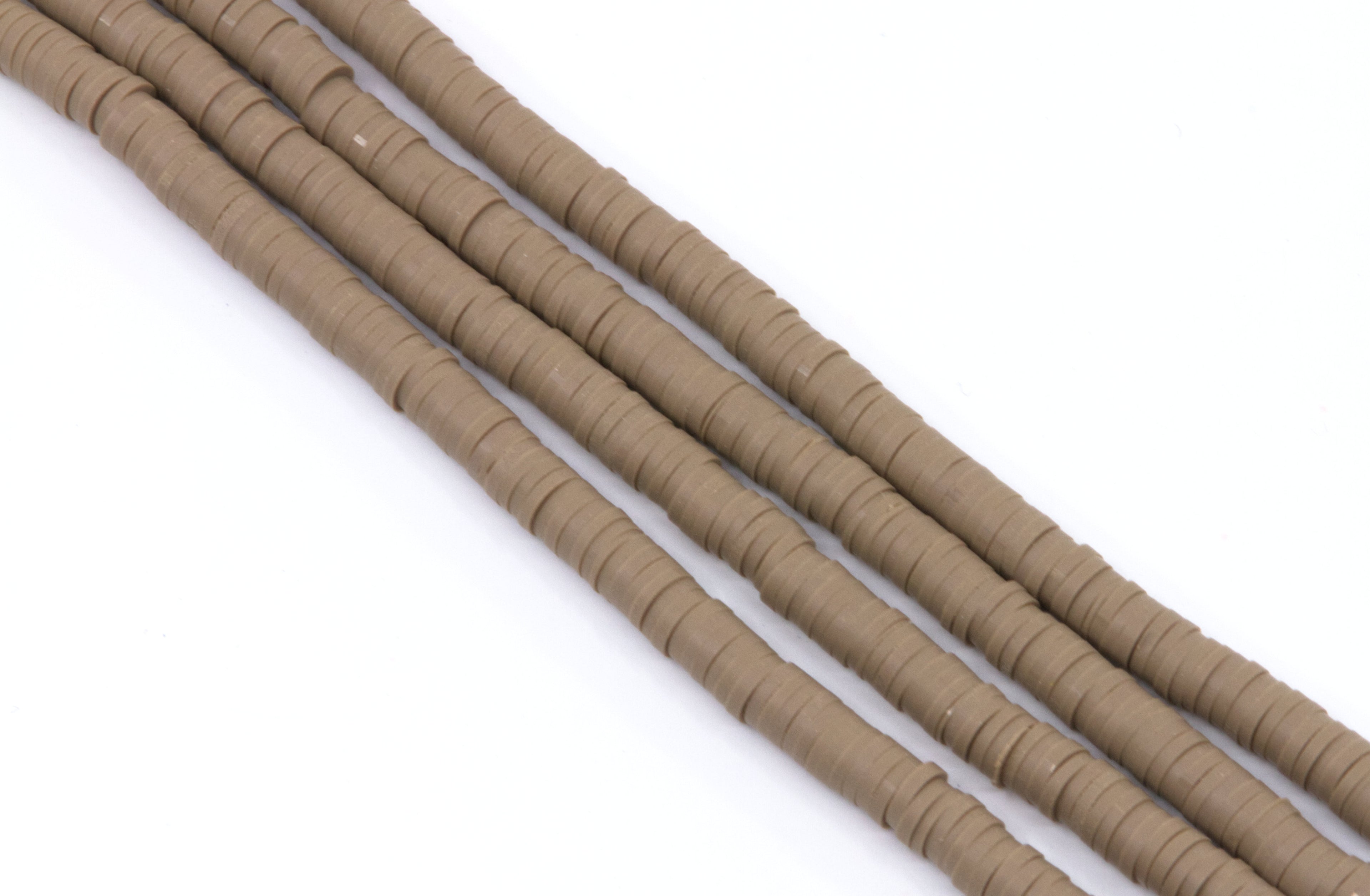 several strands of brown polymer clay disc beads arranged diagonally on a plain white background.