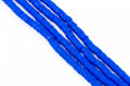 multiples strand of blue polymer clay disc beads arranged diagonally on a plain white background.