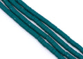 multiple strands of teal polymer clay disc beads  arranged diagonally on a plain white background.