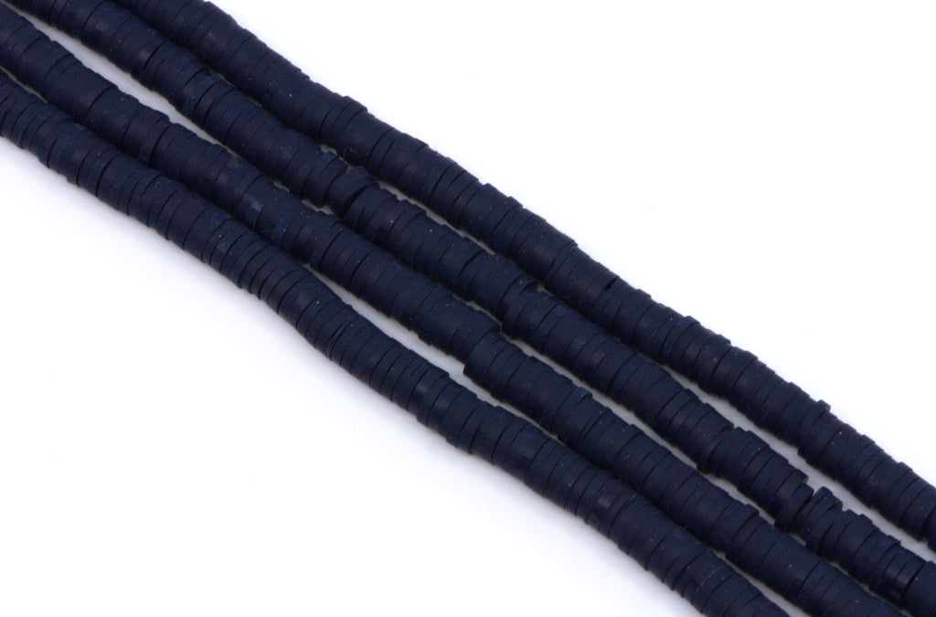 multiple strands of navy blue polymer clay beads, arranged diagonally on a plain white background.