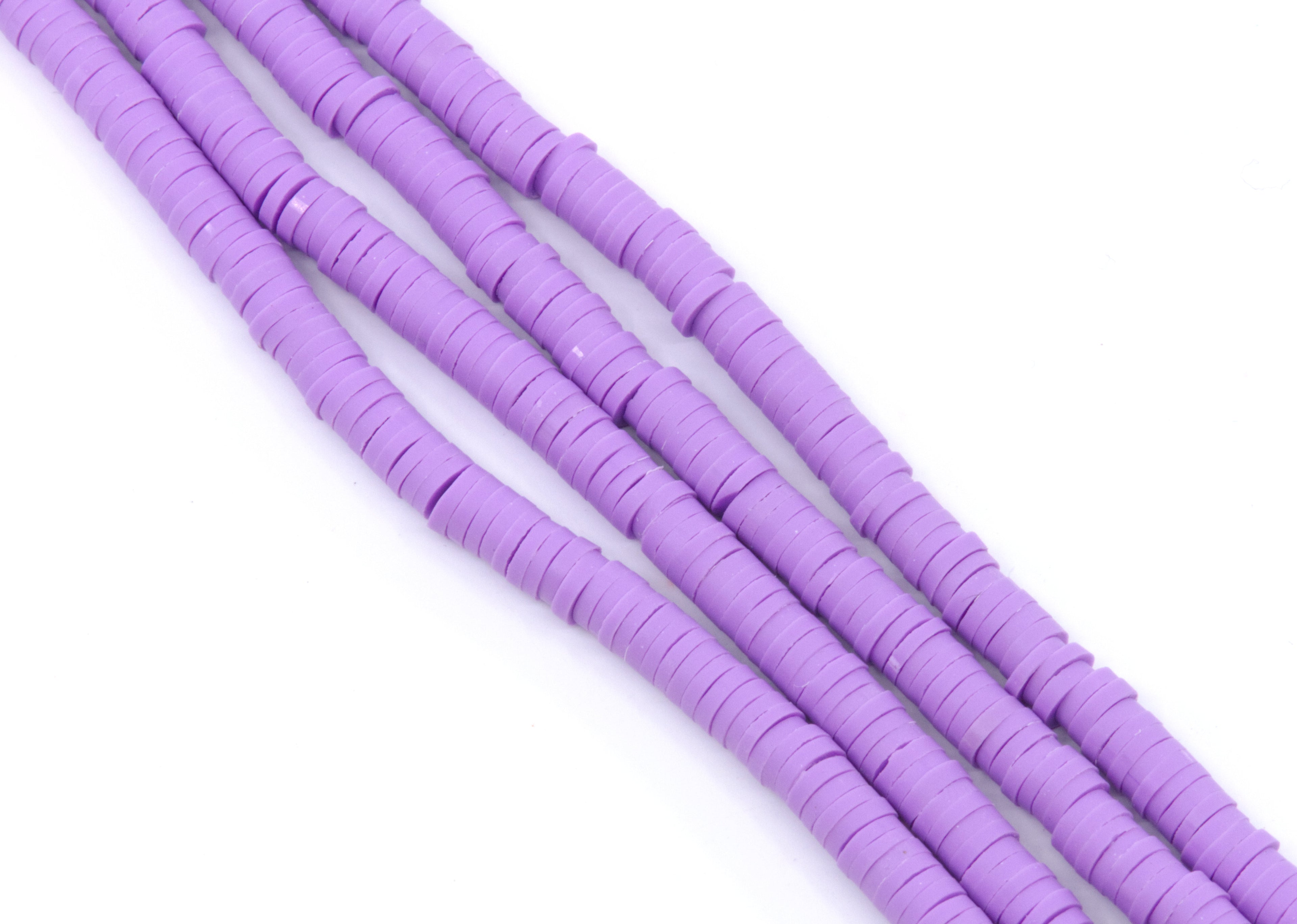 multiple strands of purple polymer clay disc beads arranged diagonally on a plain white background.