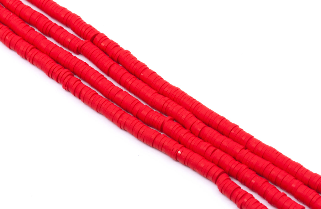 Several strands of red polymer clay disc beads arranged diagonally on a plain white background.