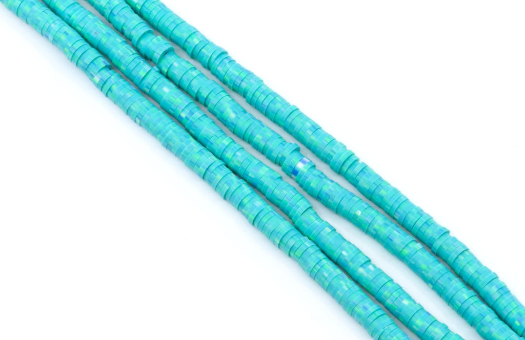 Four strands of blue polymer clay beads arranged diagonally on a plain white background.