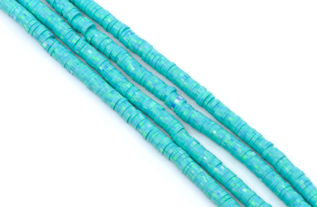 Four strands of blue polymer clay beads arranged diagonally on a plain white background.