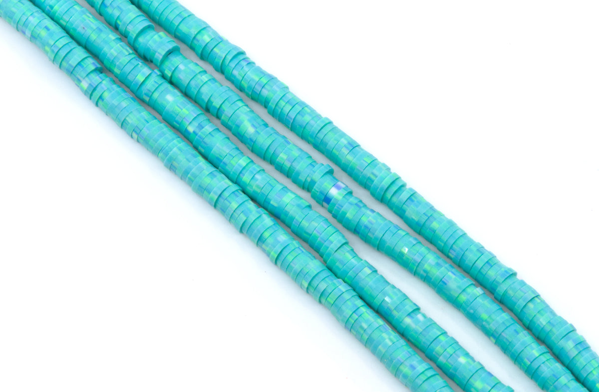 Four strands of blue polymer clay beads arranged diagonally on a plain white background.