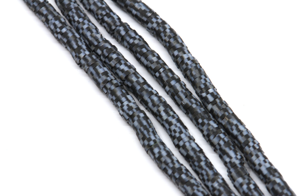 multiple strands of purple polymer clay disc beads arranged diagonally on a plain white background.