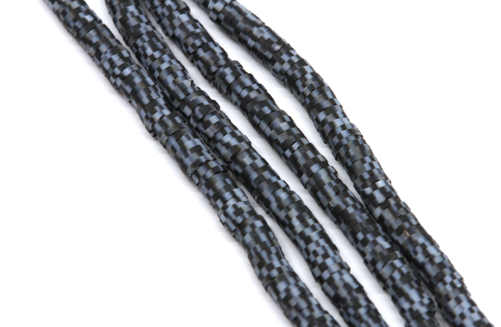 multiple strands of black and gray polymer clay disc beads arrange diagonally on a plain white background.
