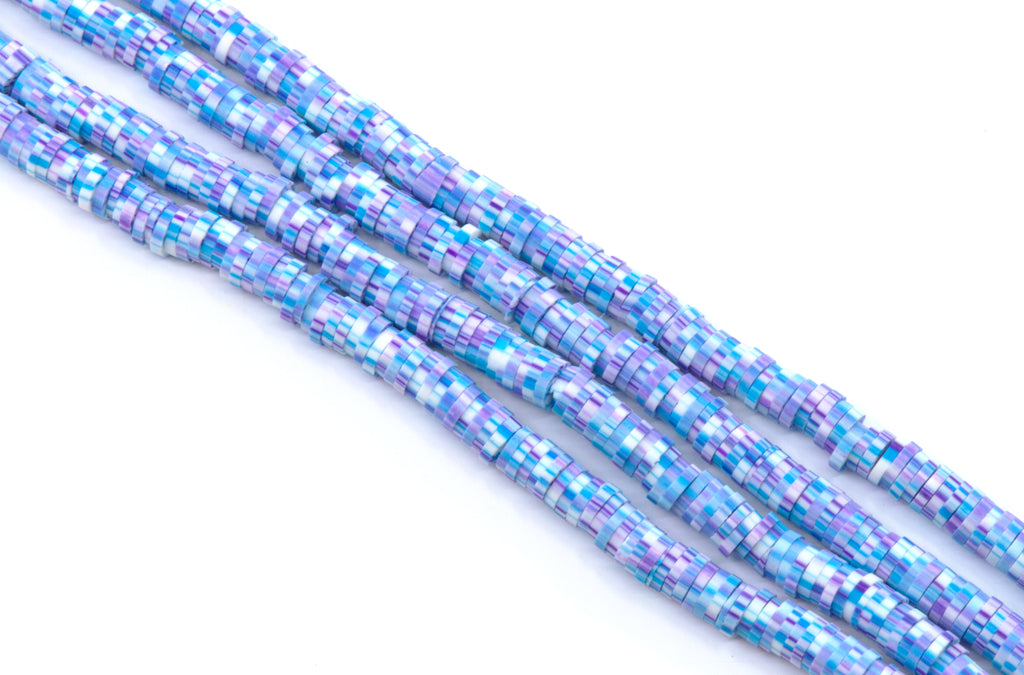 multiple strands of blue and purple polymer clay disc beads arranged diagonally on a plain white background.