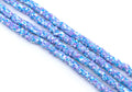 multiple strands of blue and purple polymer clay disc beads arranged diagonally on a plain white background.