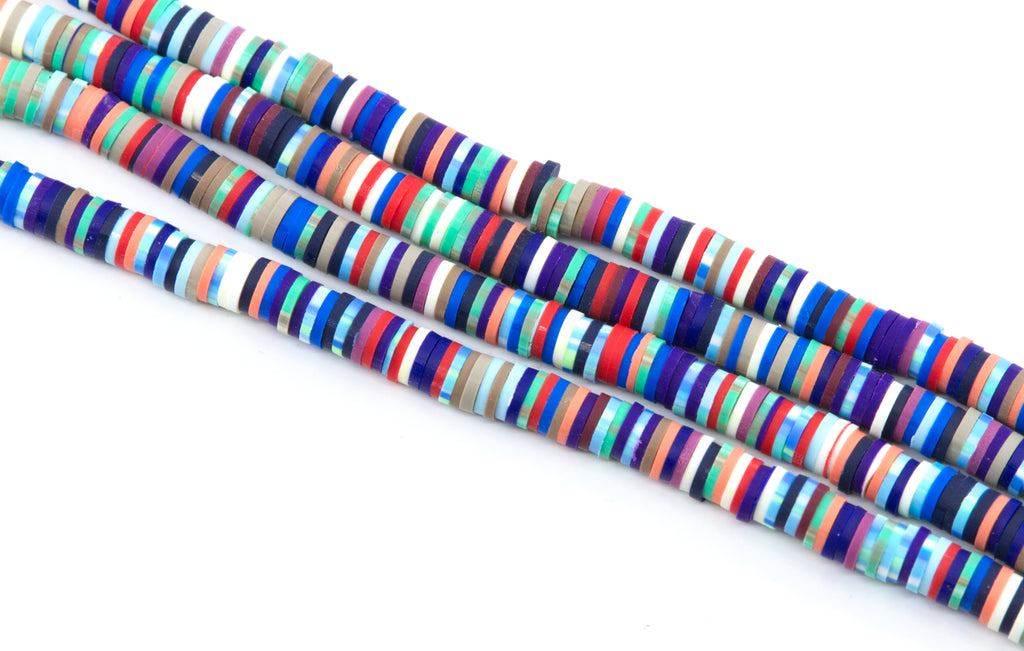 Several strands of red and blue multi-color polymer clay disc beads arranged diagonally on a plain white background.