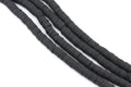 multiple strands of black polymer clay disc beads arranged in diagonal strands on a plain white background.