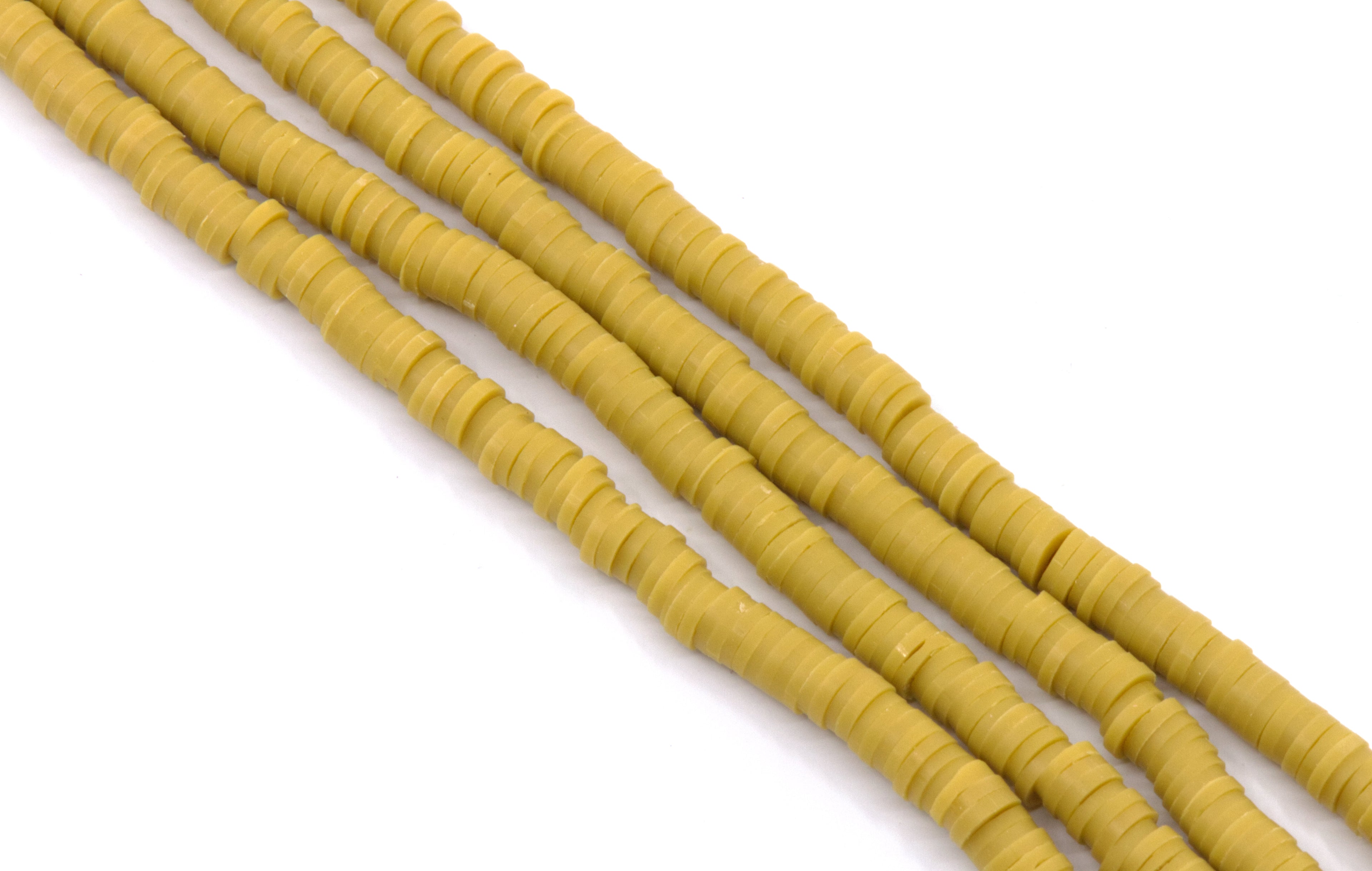 multiple strands of mustard yellow polymer clay disc beads arranged diagonally on a plain white background.
