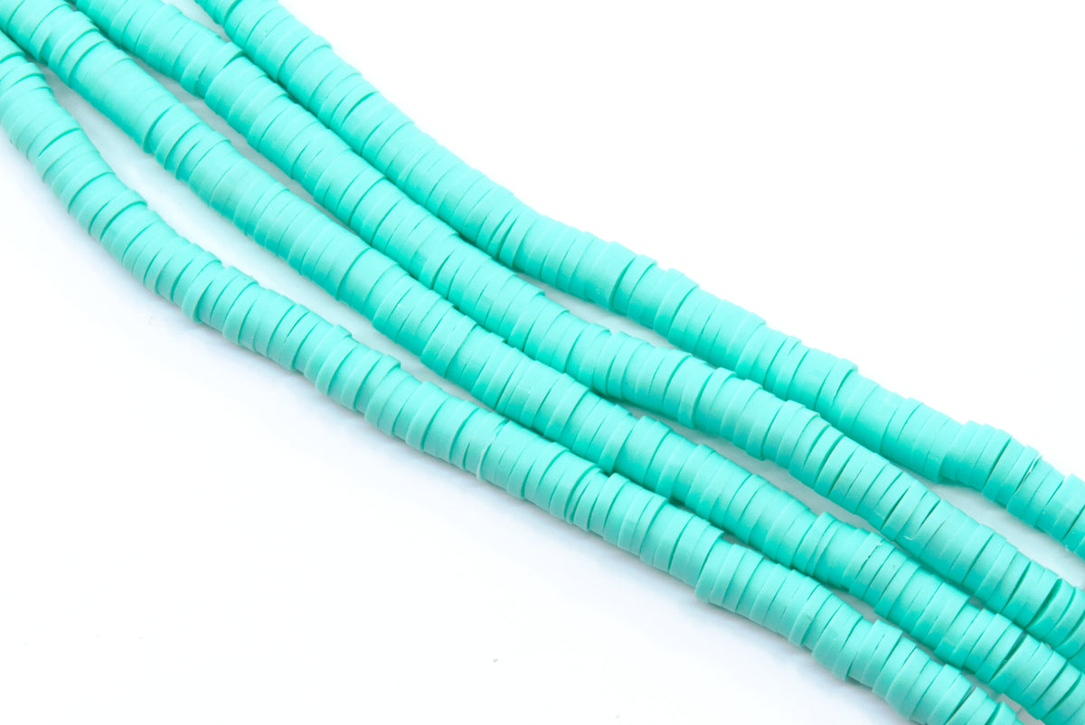 multiple strands of blue polymer clay disc beads arranged in diagonal strands on a clean white background.