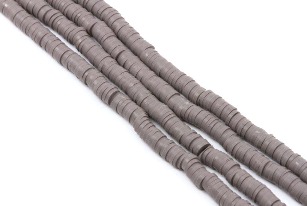 Four strands of gray polymer clay disc beads arranged diagonally on a plain white background.