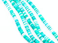 multiples strands of blue and green polymer clay disc beads arranged in diagonal strands on a white background.