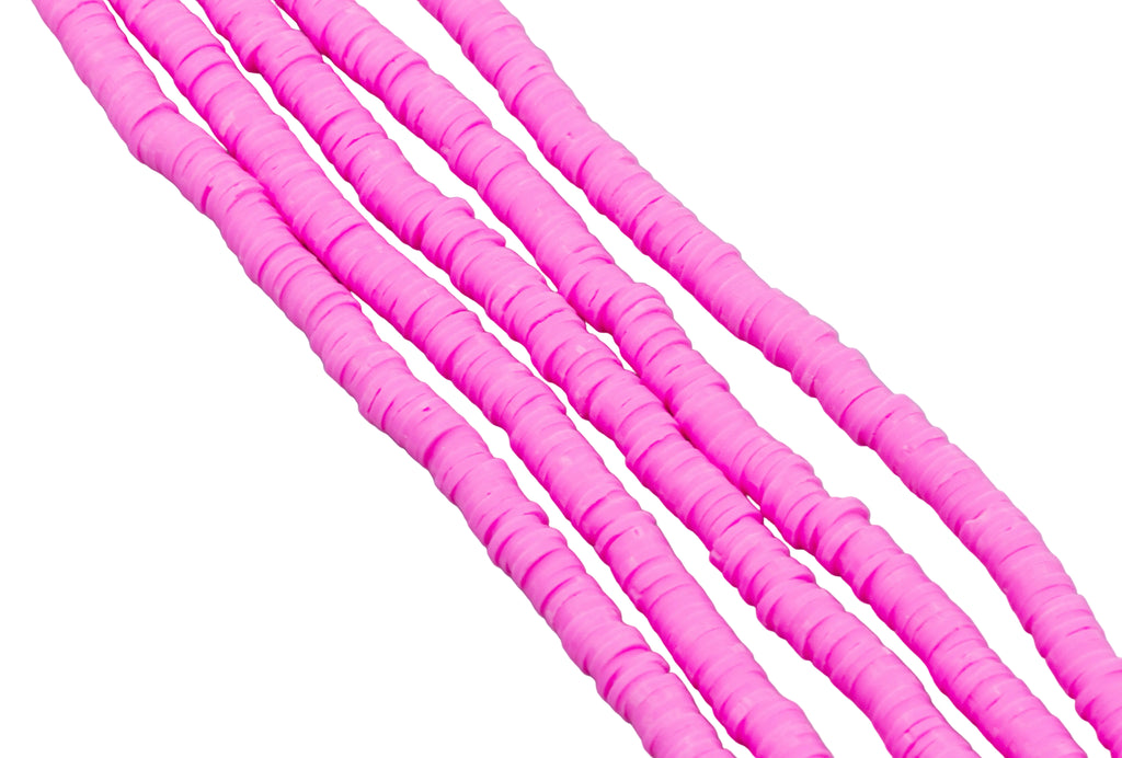 multiple strands of pink polymer clay disc beads arranged diagonally on a plain white background.