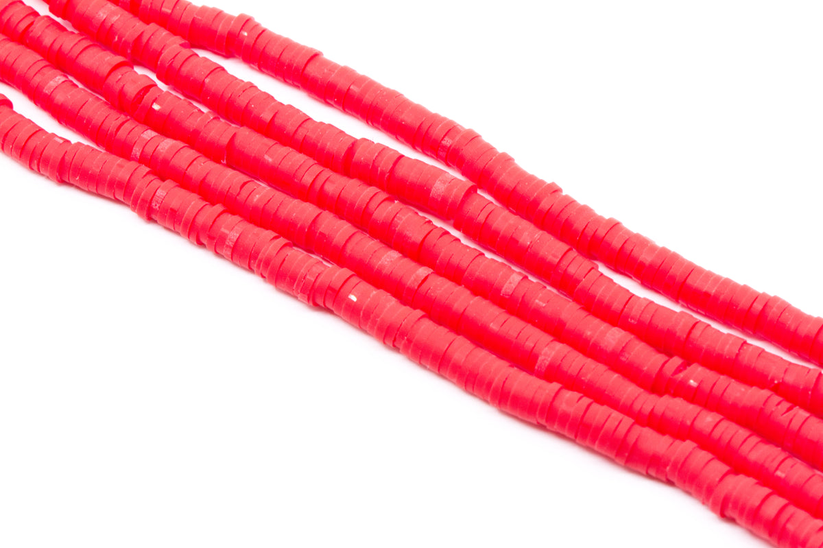 Several strands of bright red polymer clay disc beads arranged diagonally on a plain white background.