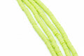 four strands of green polymer clay beads shown diagonally on a white background 