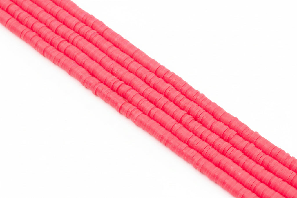 A close-up of several strands of bright pink polymer clay disc beads arranged diagonally on a plain white background.