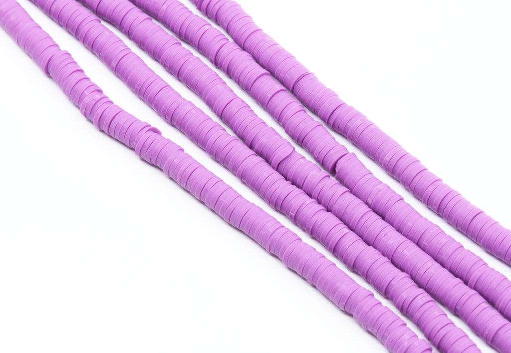 multiple strands of purple polymer clay disc beads shown diagonally on a plain white background.