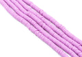 multiple strands of purple polymer clay disc beads arranged diagonally on a plain white background.