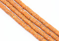Orange speckled polymer clay beads on a white background