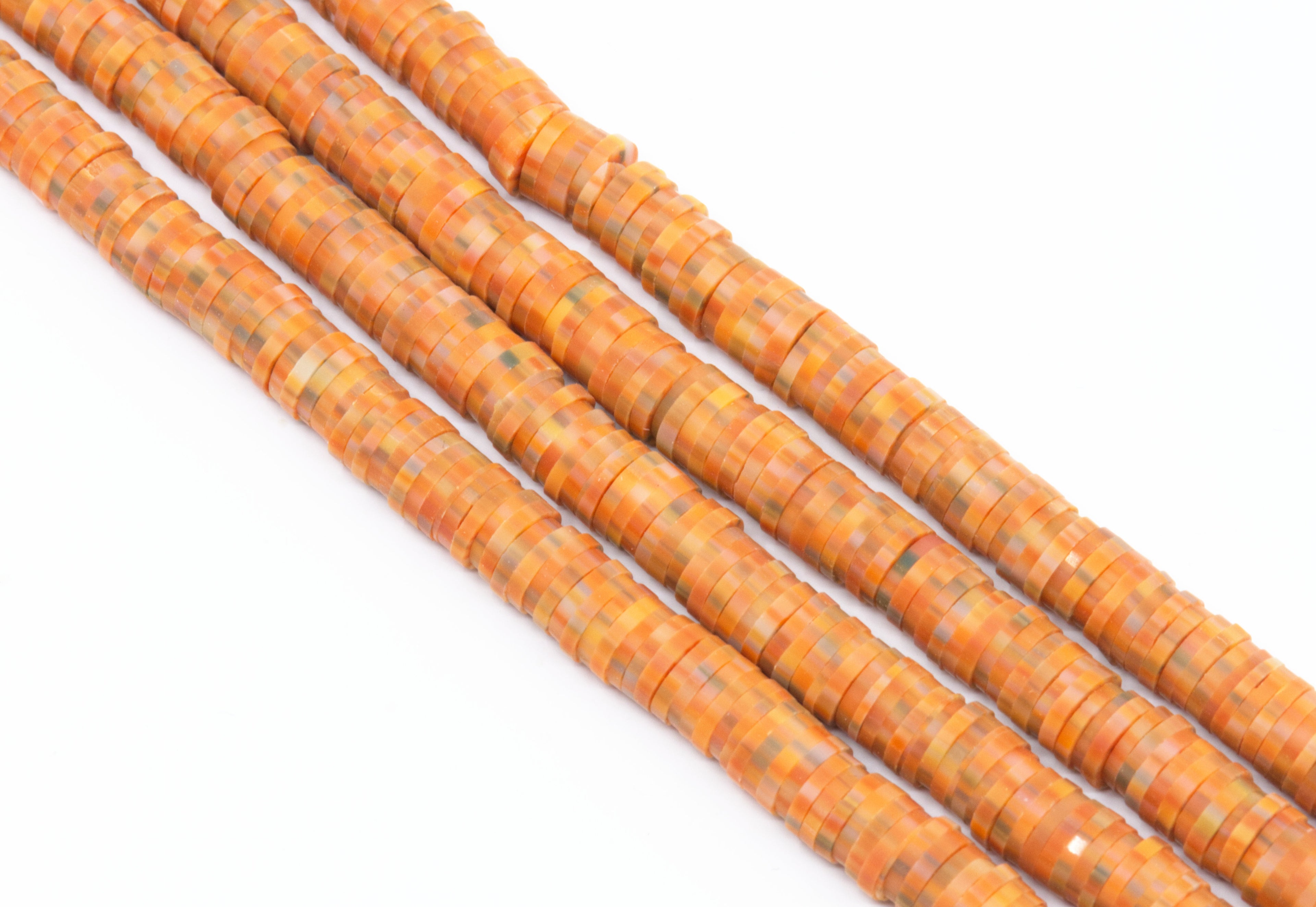 Orange speckled polymer clay beads on a white background