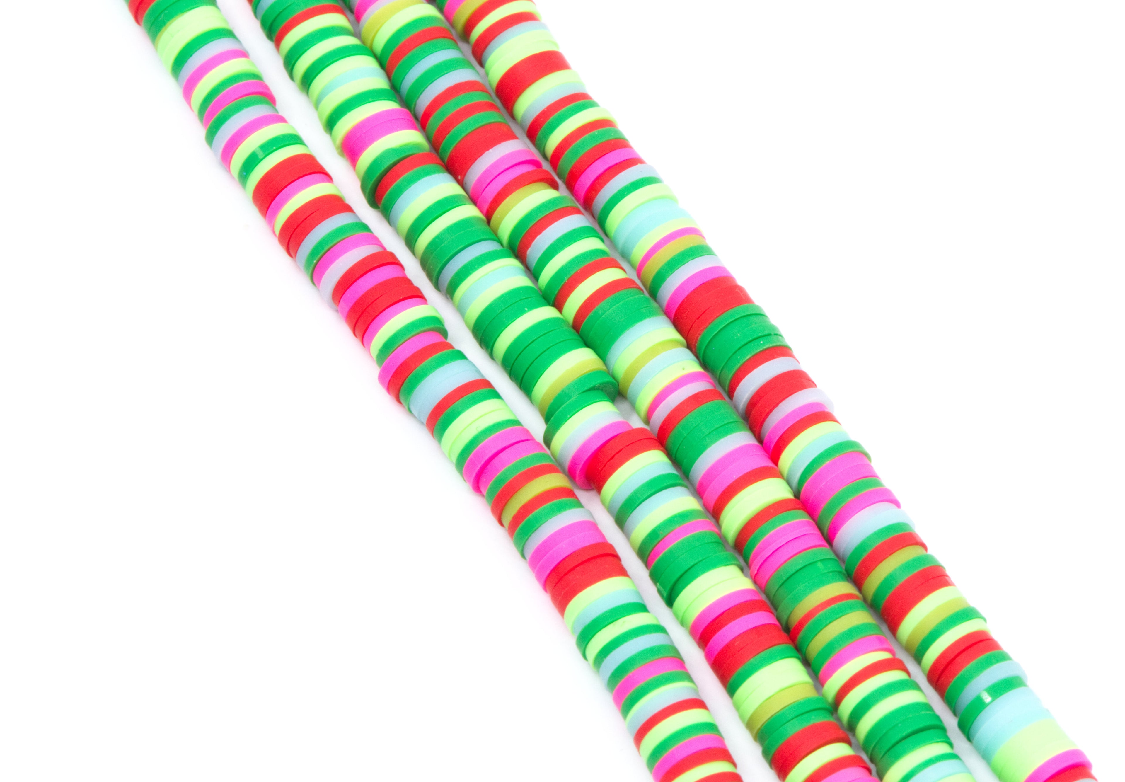 Four strands of colorful green and pink polymer clay disc beads arranged diagonally on a plain white background.