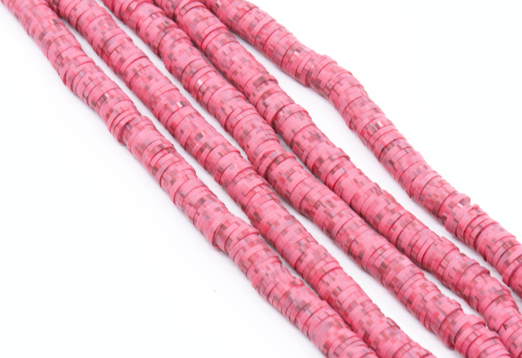 Several strands of red polymer clay disc beads arranged diagonally on a plain white background.