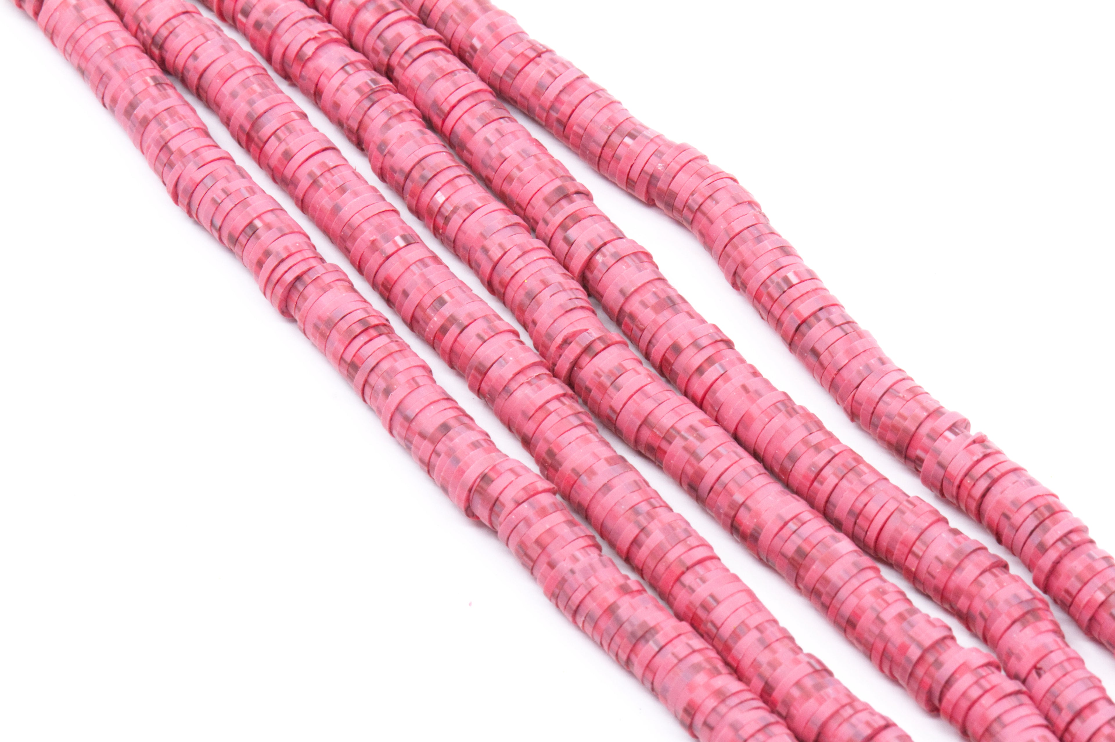 Several strands of red polymer clay disc beads arranged diagonally on a plain white background.