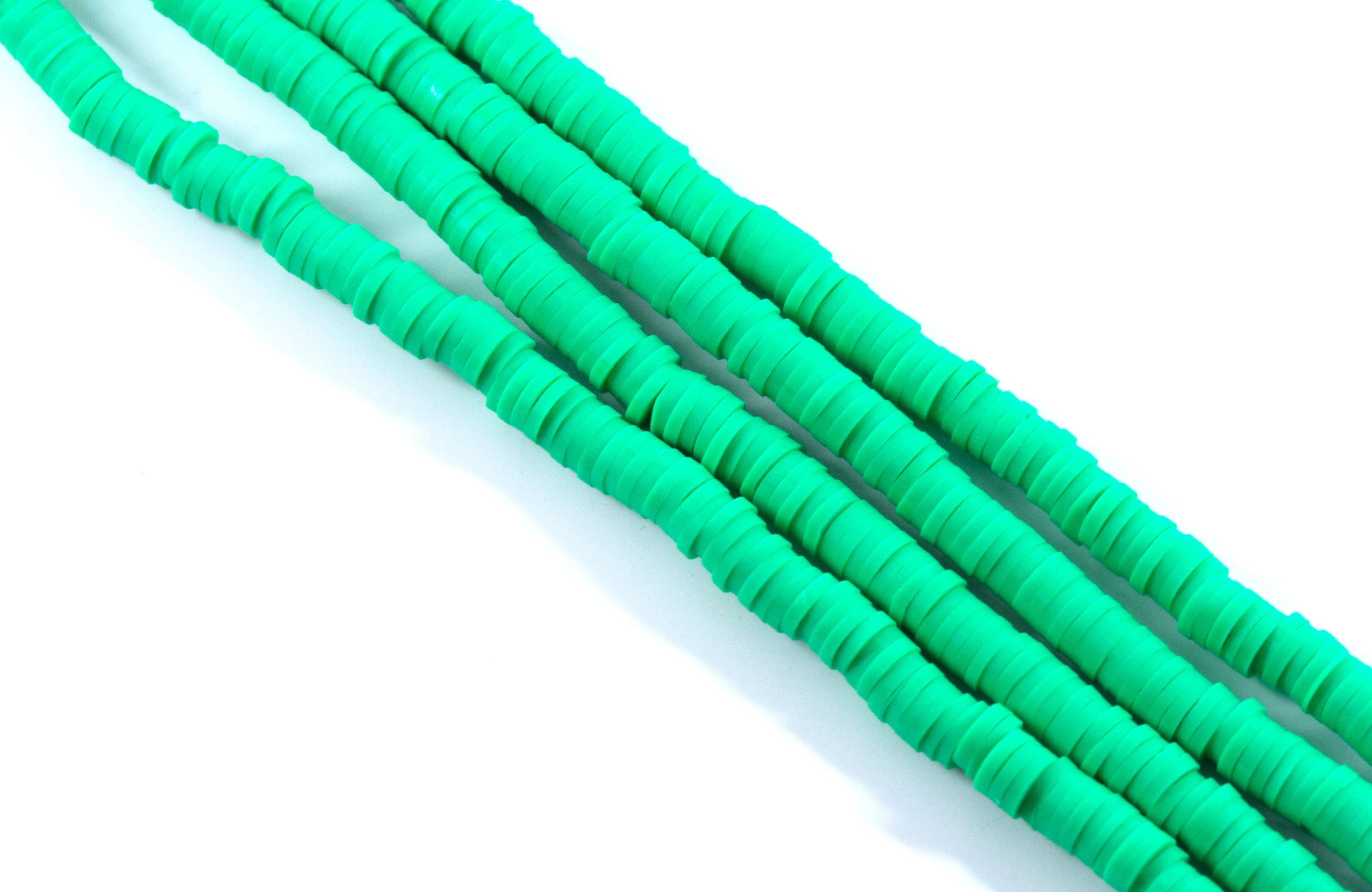 four strands of green polymer clay beads displayed on a white background.