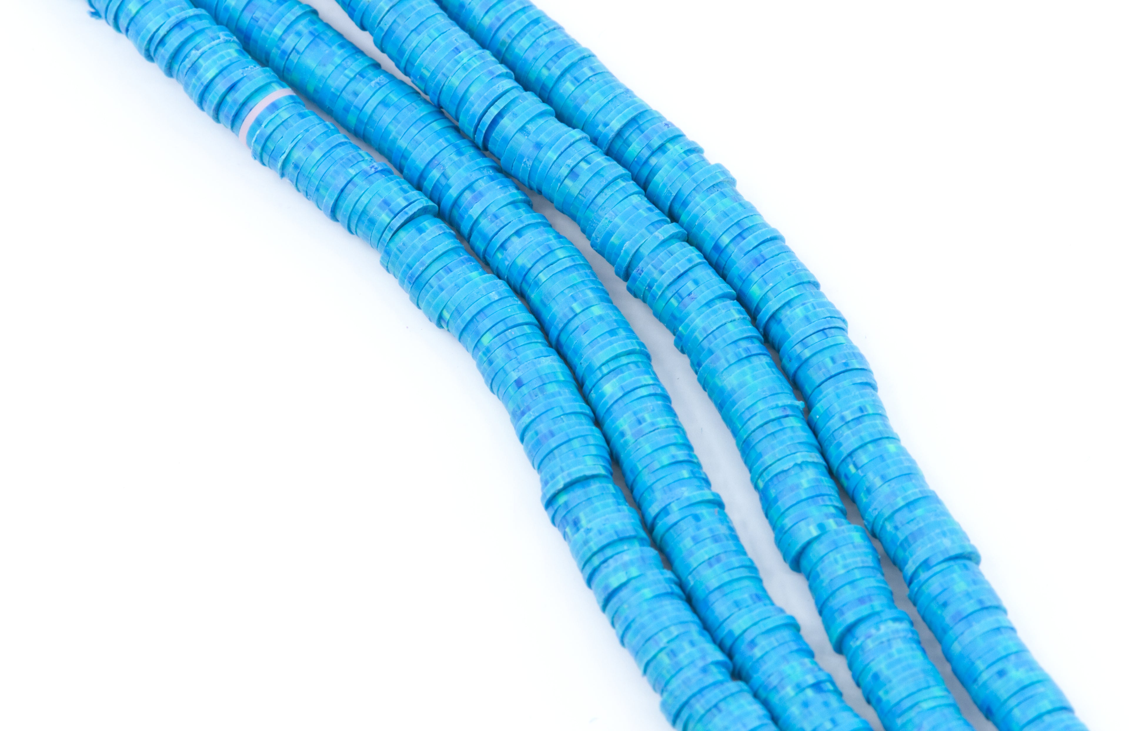 Four strands of bright blu and green speckled polymer clay disc beads arranged diagonally on a plain white background.