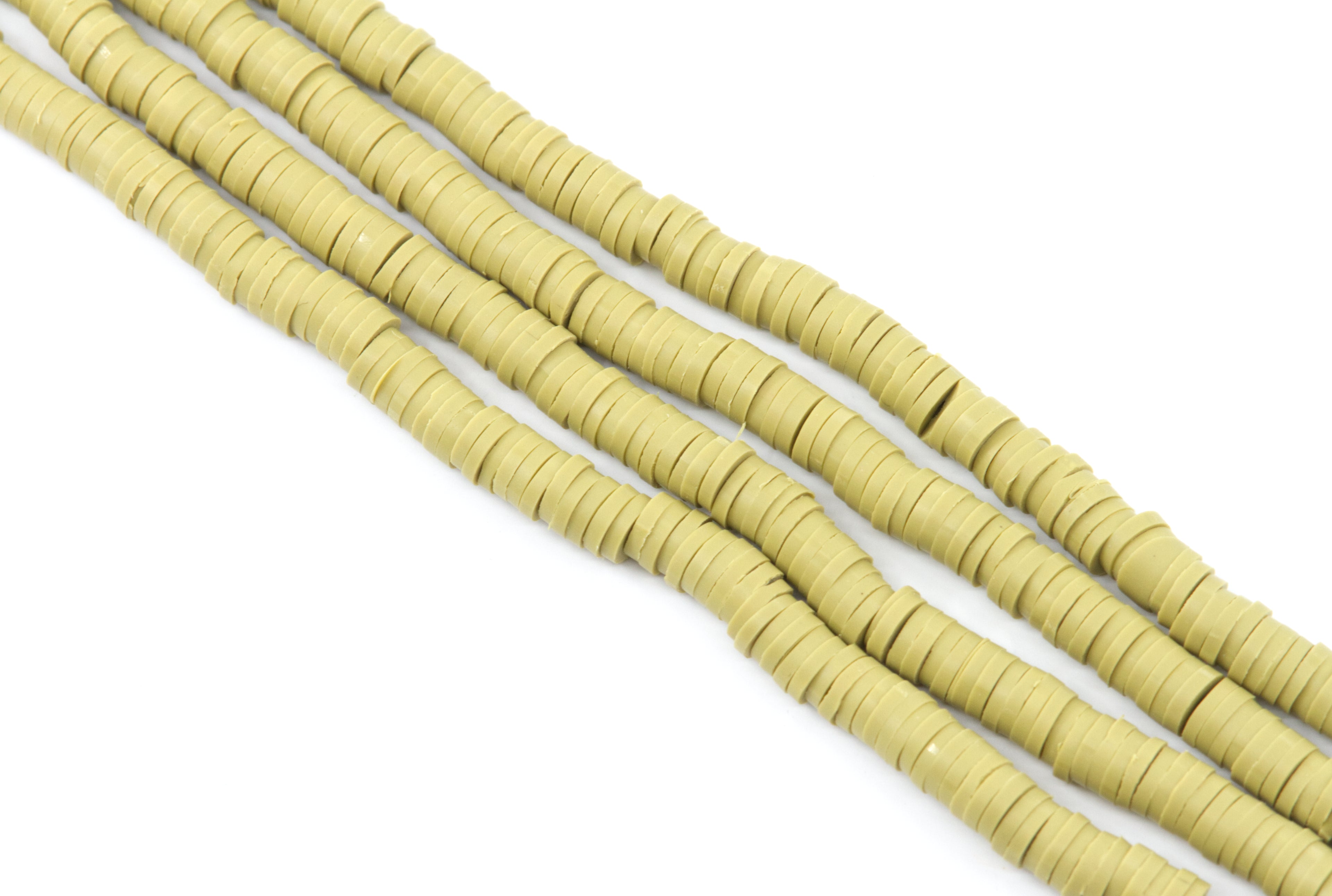 multiple strands of tuscan green polymer clay disc beads, arranged diagonally on a plain white background.