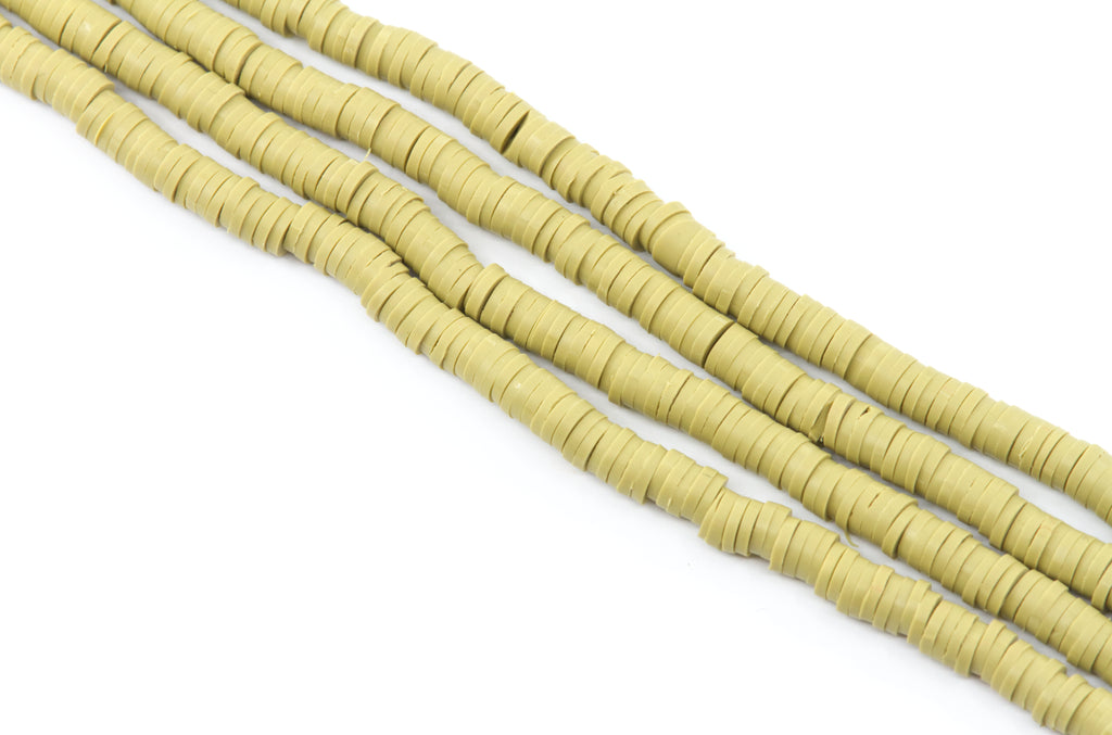 multiple strands of tuscan green polymer clay disc beads, arranged diagonally on a plain white background.
