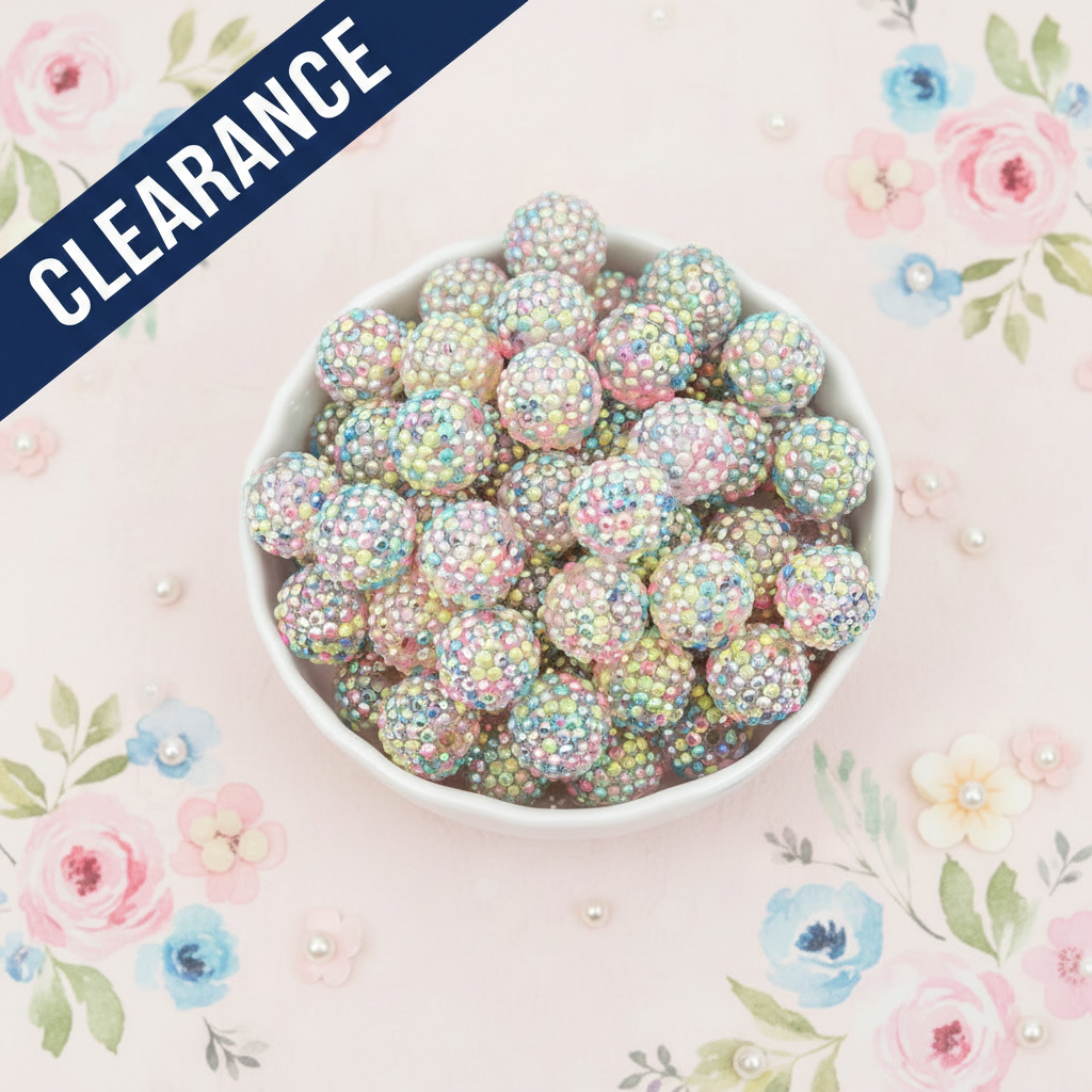 White bowl filled with pastel-colored, rhinestone beads on a floral-patterned background with a clearance banner
