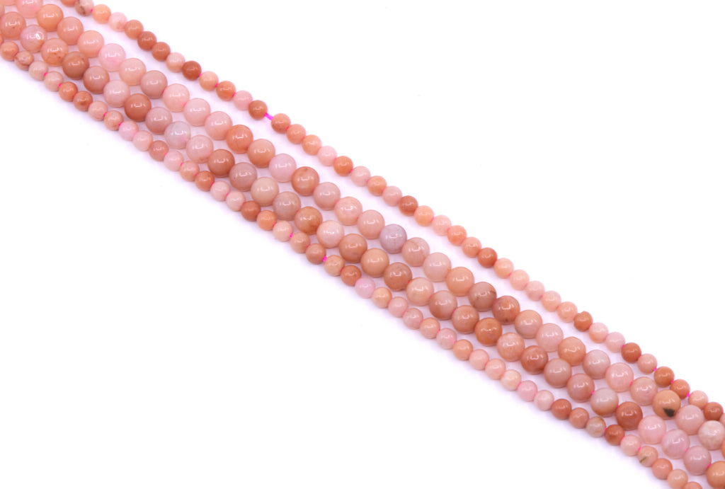 four strands of dark pink aventurine beads arranged diagonally on a white background.