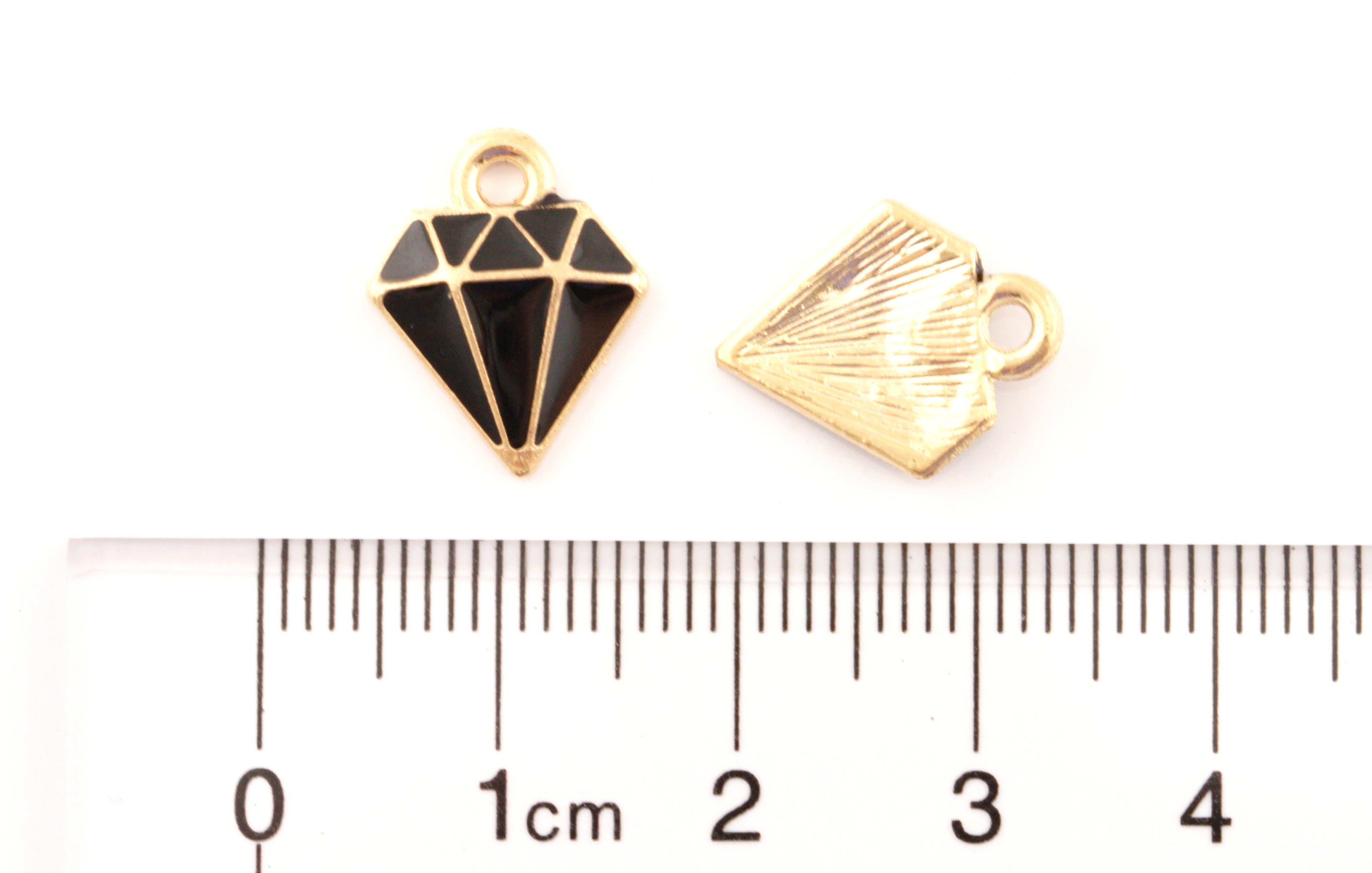 Two small jewelry charms shaped like diamonds, shown above a ruler for scale on a white background.