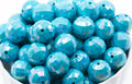 light blue faceted beads in a white bowl on a white background