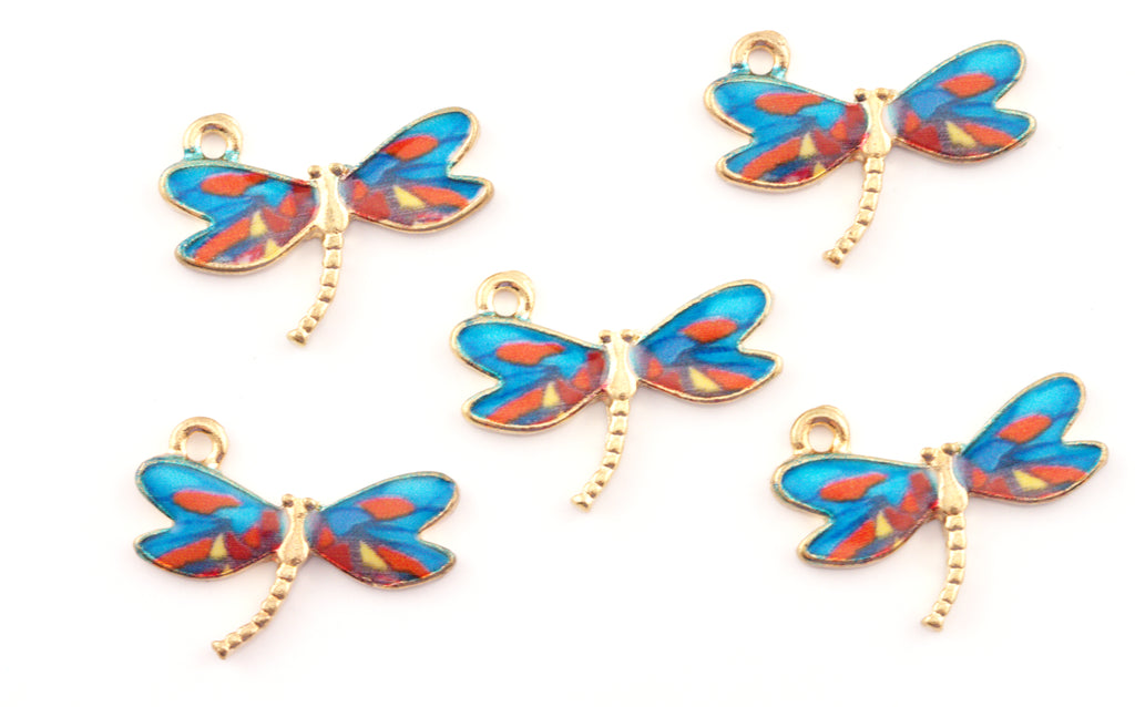 Five dragonfly-shaped jewelry charms with gold-tone metal bodies and wings featuring blue, red, and orange patterns, arranged on a plain white background.