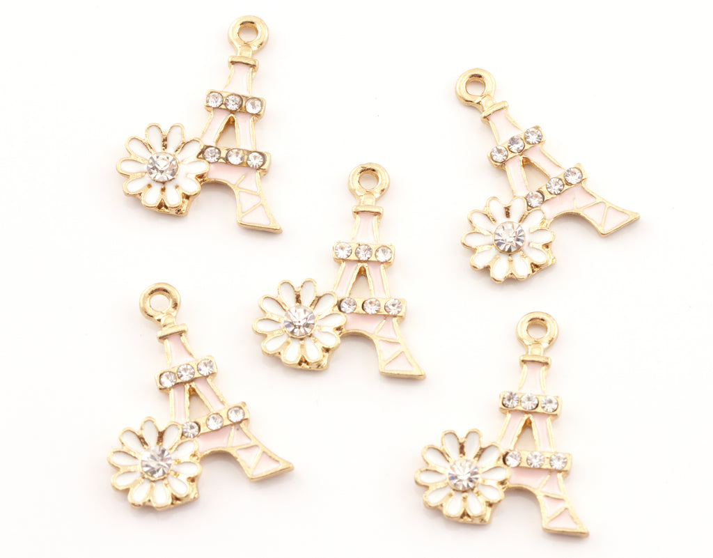 Five pink Eiffel Tower charms, each decorated with a small white flower and clear rhinestones, arranged on a plain white background.
