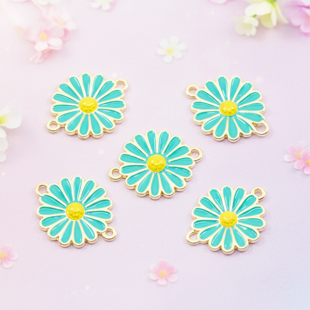 Five blue and yellow daisy flower charms with gold-tone metal edges and loops, arranged on a light pink background with small floral decorations.