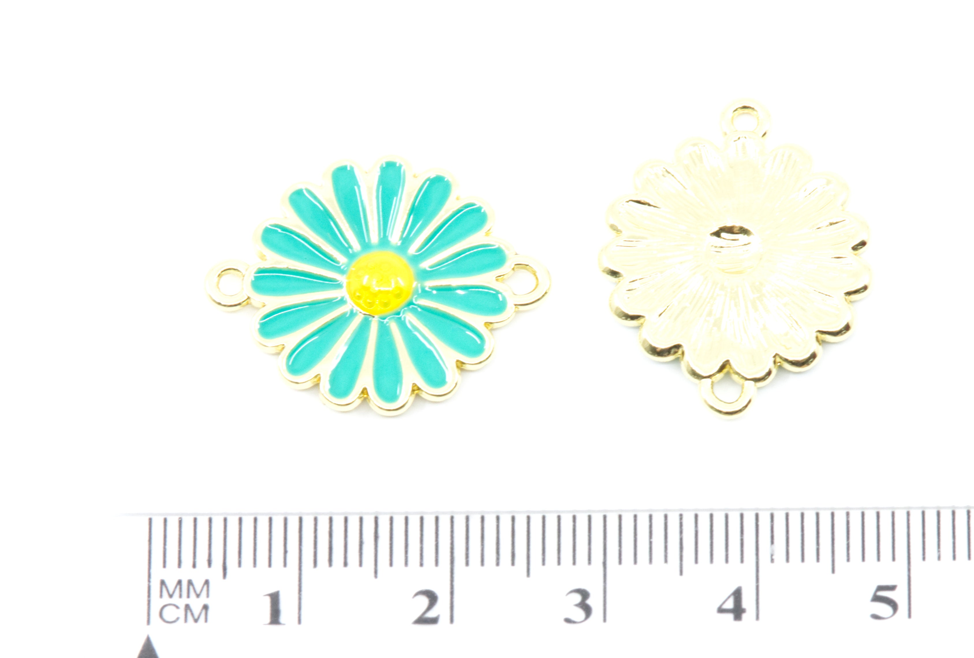 Two flower-shaped enamel charms on a white background, one turquoise and yellow enamel front view and one gold-toned back view, with a cm ruler below for scale.
